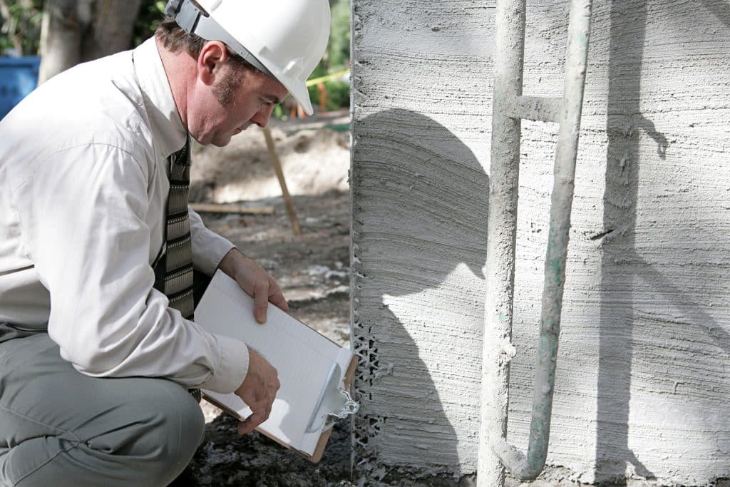 foundation inspection Inspector checking a foundation wall for cracks