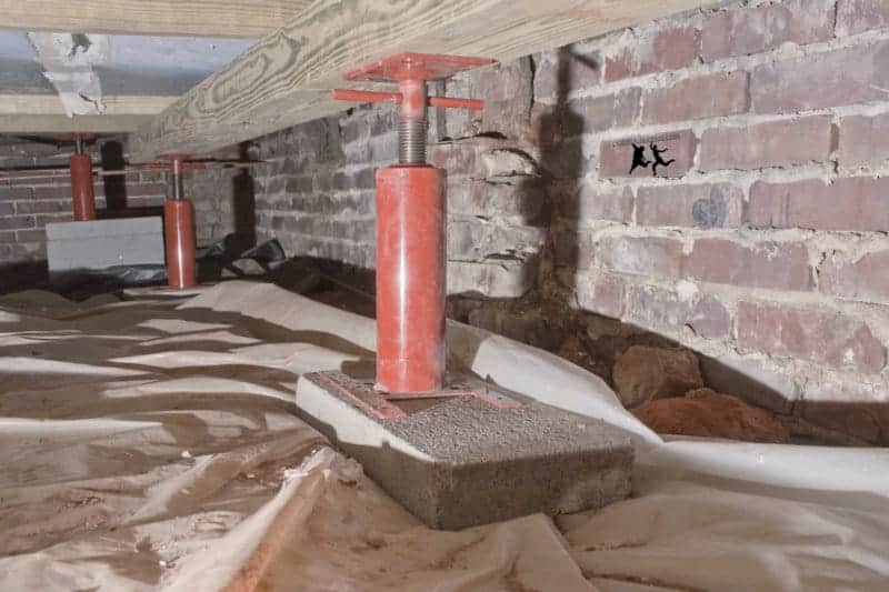 Hydraulic house jacks leveling a foundation in a Los Angeles crawl space