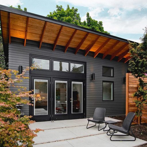 Modern backyard cottage with slanted roof and patio