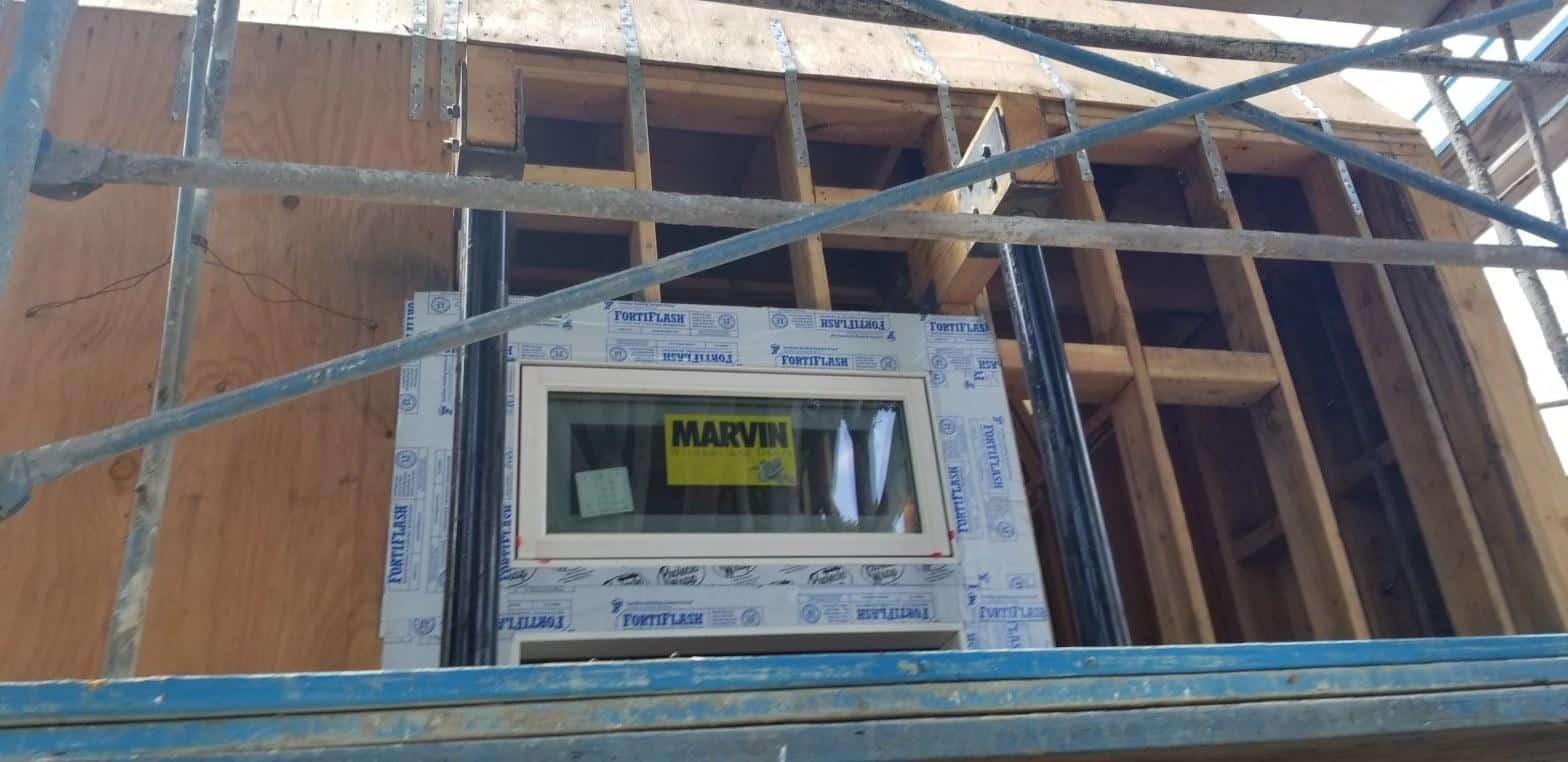 Marvin window unit installed in wood-framed rough opening with Fortiflash self-adhering flashing tape on all four sides