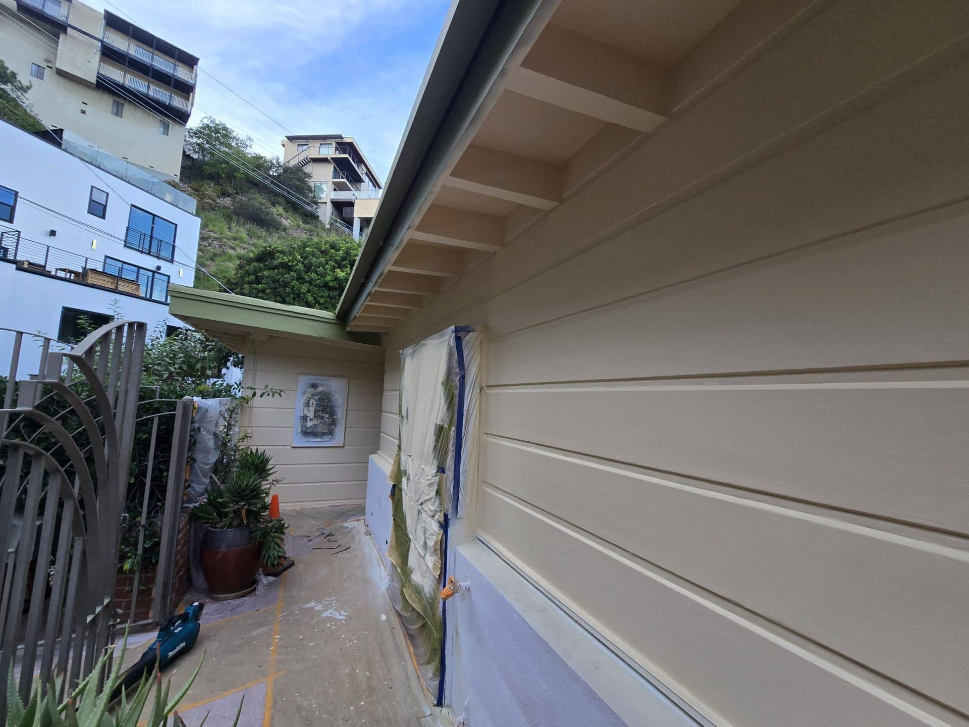 Freshly painted lap siding with masking tape and drop cloth protection — Hollywood Contractor Corp