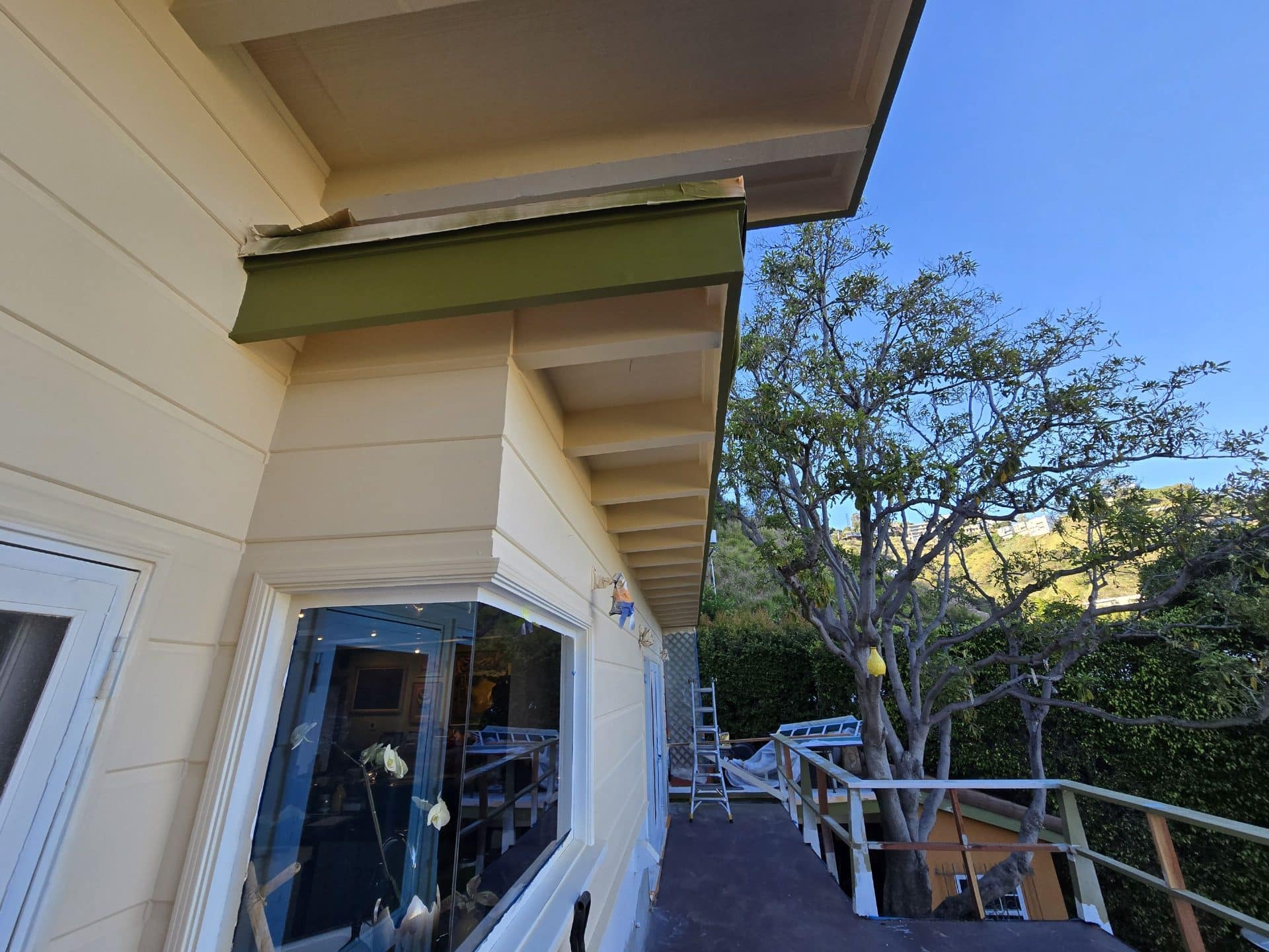 Exterior eave soffit with exposed rafters, gutter flashing, deck balcony | Hollywood Contractor Corp Exterior eave soffit with exposed rafters, gutter flashing, deck balcony — Hollywood Contractor Corp