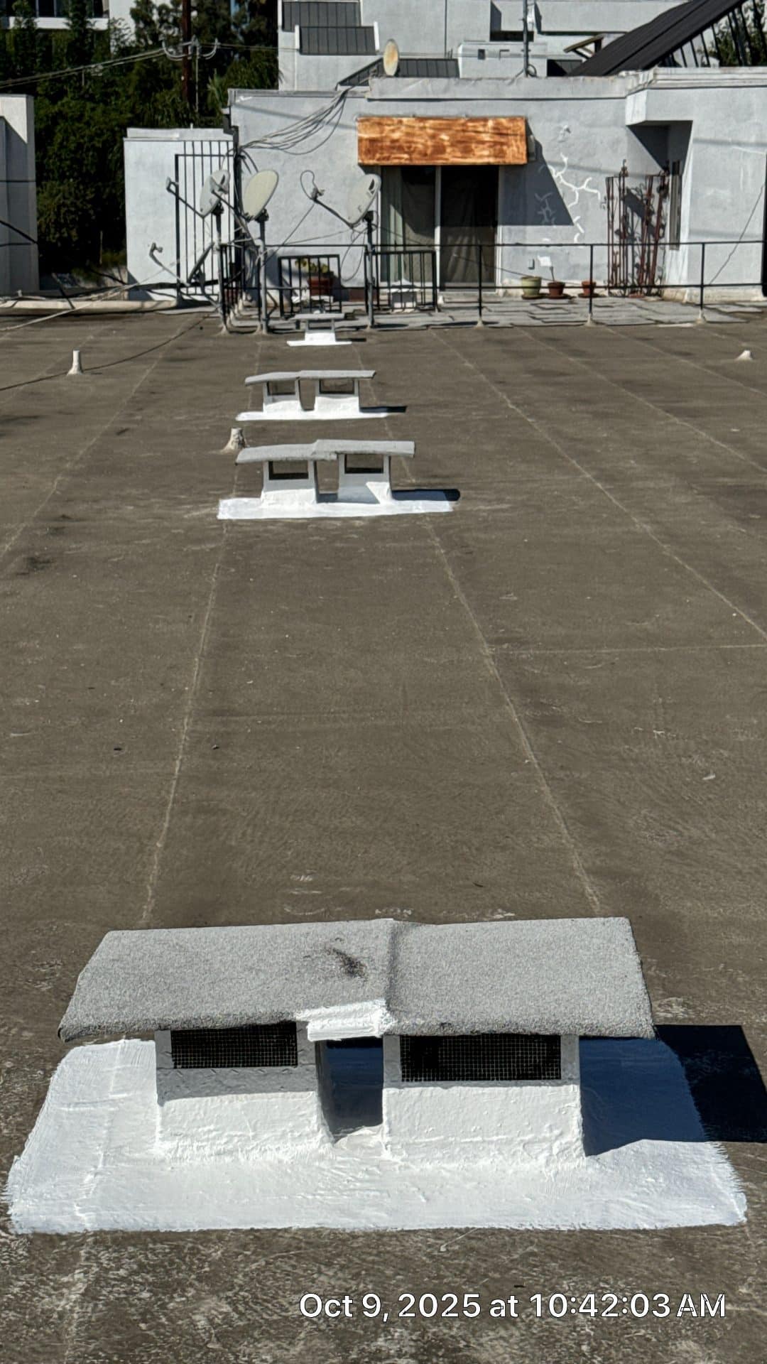 Flat roof with skylight vents sealed using white elastomeric coating in West Hollywood | Hollywood Contractor Corp Flat roof with skylight vents sealed using white elastomeric coating — West Hollywood — Hollywood Contractor Corp