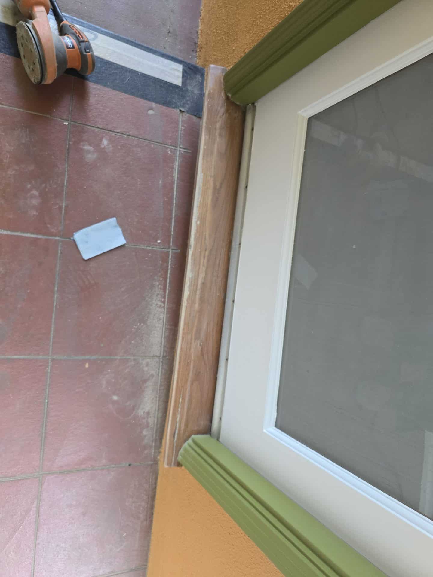 Sanded wood window casing beside white vinyl window, orbital sander nearby — Hollywood Contractor Corp