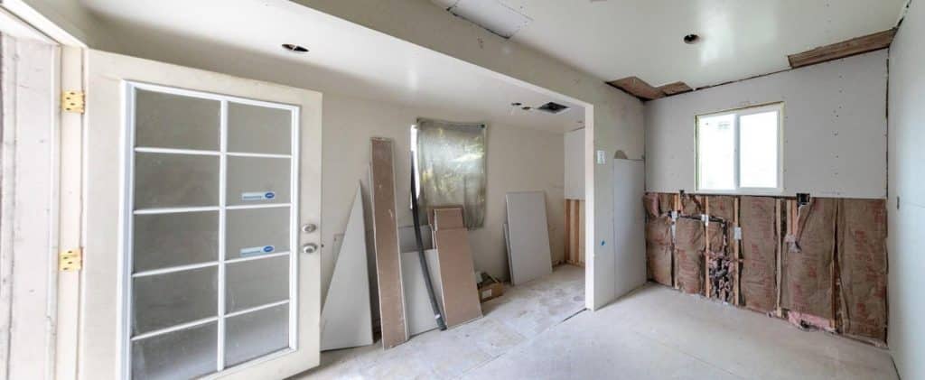 Crawl space interior of a raised California home foundation showing block walls, wood beams, and vapor barrier