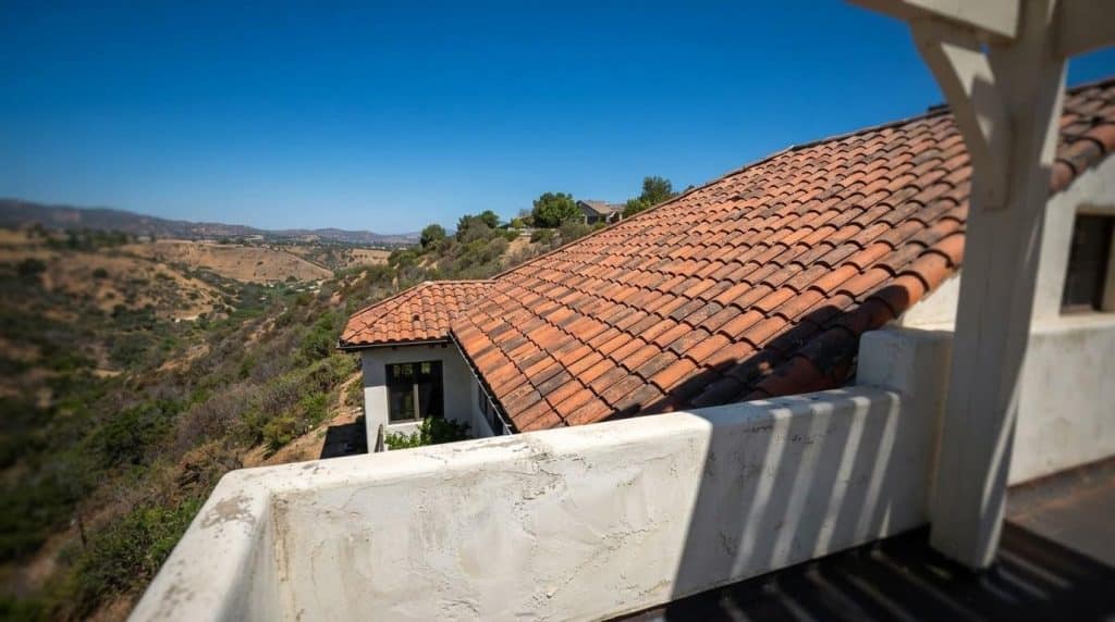 Steep-pitch clay tile roof on a hillside home in Southern California showing dramatic lot grade drop